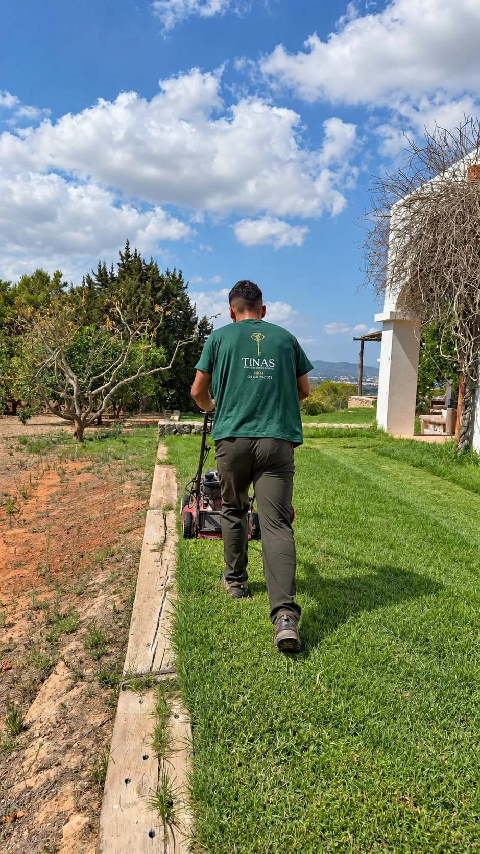 TINAS team member mowing a villa lawn